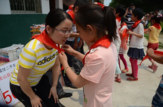 捐贈儀式上，孩子們?yōu)閻坌奶焓瓜瞪霞t領(lǐng)巾