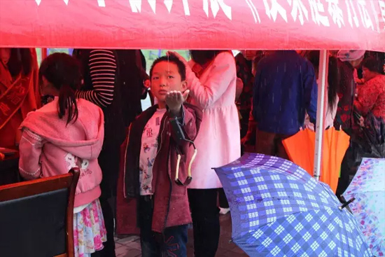 因?yàn)橛晗碌奶?，小男孩玩起了接水游戲? complete=