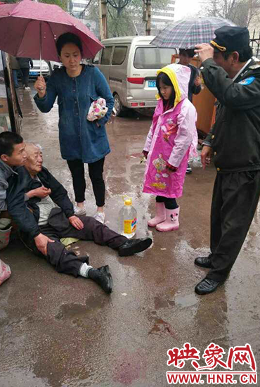 女孩為倒地老人撐傘。