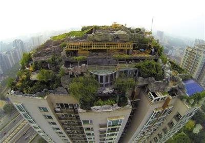 　　昨日，身穿橘黃色馬甲的工作人員在人濟(jì)山莊樓頂拆除違章建筑。新京報記者 吳江 攝