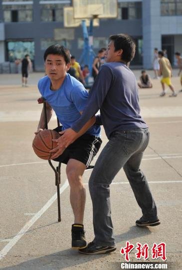圖為拄著拐杖的瞿詩濤和同學(xué)搶球。劉占昆攝