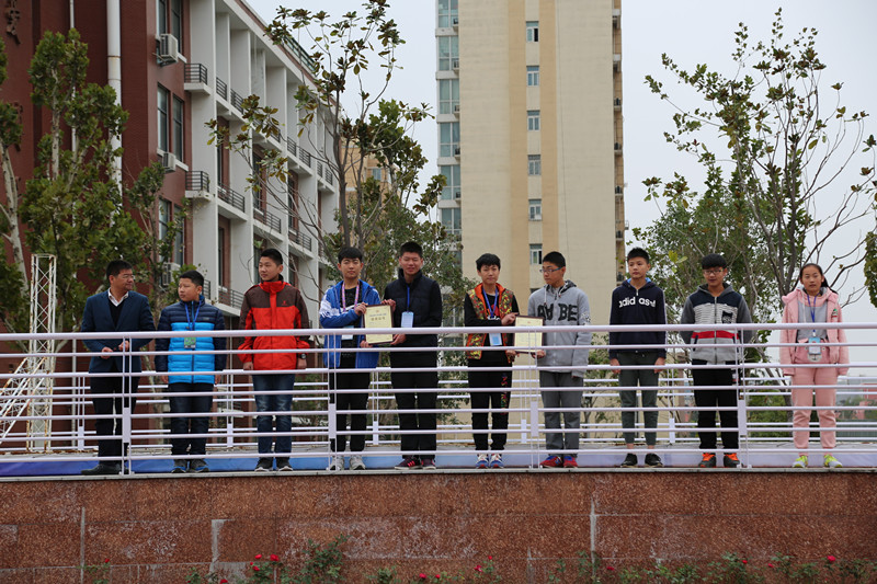 副校長(zhǎng)賈軍杰（左一）為創(chuàng)新機(jī)器人社團(tuán)的學(xué)生頒發(fā)證書