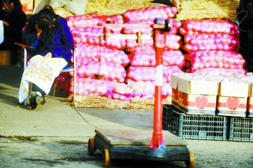 水果批發(fā)市場內(nèi)，沒有客戶時，商戶在繡十字繡