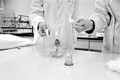 實驗人員操作的燃燒檢測法中，真蠶絲離開火焰就熄滅(左)。