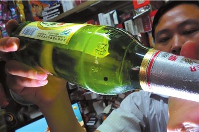 這瓶未開封的燕京啤酒內(nèi)有一顆黑色懸浮物。京華時報記者 徐曉帆 攝