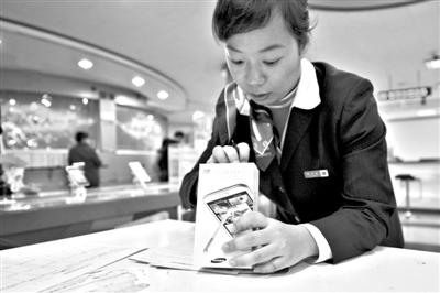 11月6日，北京移動西直門營業(yè)廳的工作人員在為顧客購買的4G手機登記。新華社發(fā)