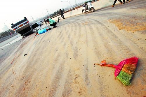 被撞的環(huán)衛(wèi)工躺在地上，身上蓋著藍(lán)色布?jí)K，現(xiàn)場(chǎng)除散落的汽車(chē)碎片外，還留有被撞斷的掃帚。