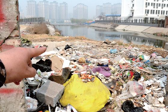 金水河長江路橋下河水發(fā)臭，水邊堆放眾多垃圾