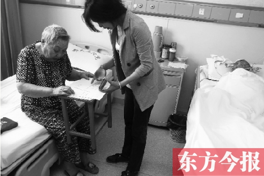 昨日，鄭大五附院二號(hào)樓住院部，馬老太寫下委托書，并簽字摁指印委托女兒代理為昏迷老伴解鎖取錢