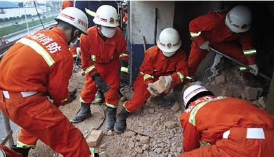 消防人員在清理熔鹽爐倒塌的廢墟。