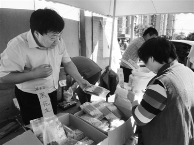 昨日，河南企業(yè)家劉春喜在京“練攤”，為顧客挑選綠豆。新京報(bào)記者 張玉學(xué) 攝