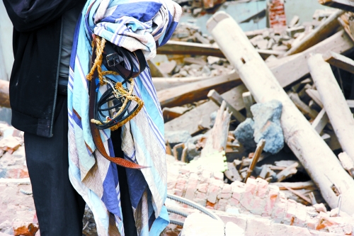 老人手中拿著曾控制住他的電線、床單