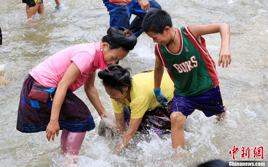 7月9日，村民在小河里摸魚搶魚。譚凱興 攝