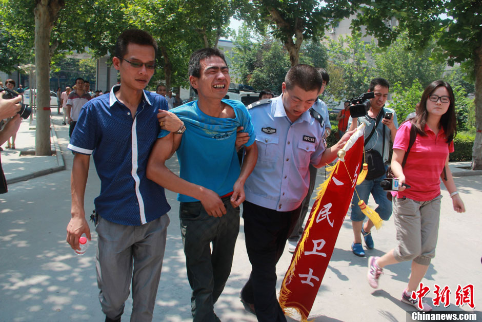 圖為獲救嬰兒父親情緒一度失控，當(dāng)?shù)鼐焦ぷ魅藛T對(duì)其進(jìn)行攙扶。張一辰 攝