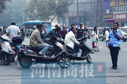 　火車站廣場北側(cè)，幾輛摩的正在等客