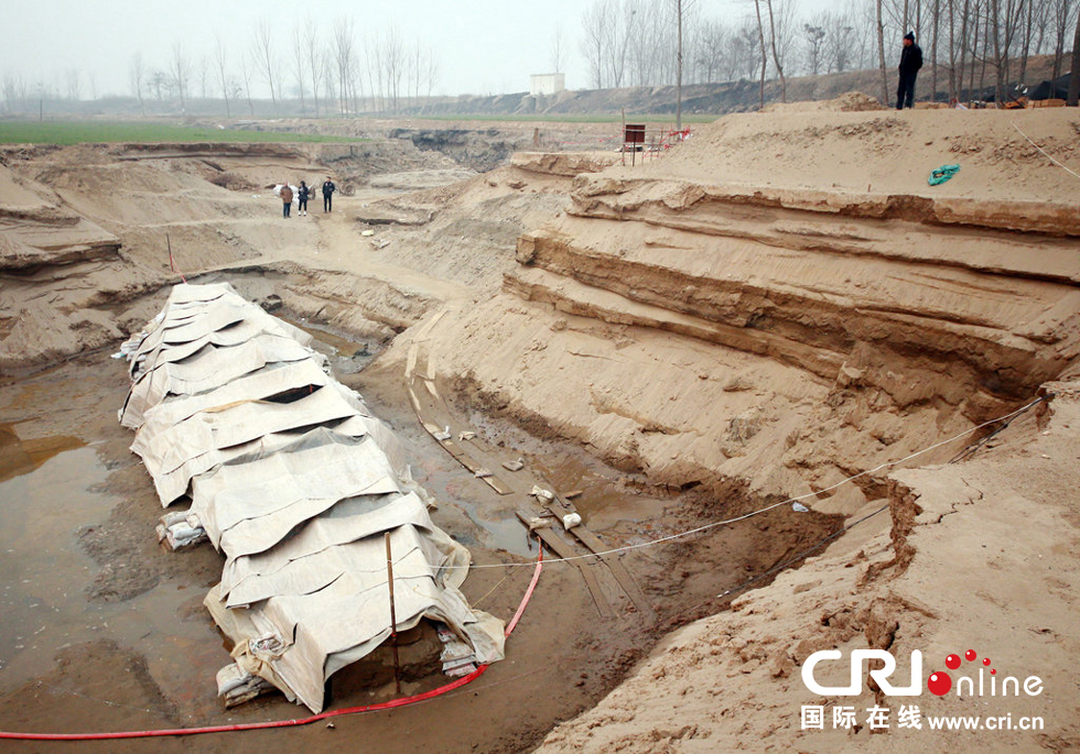 2014年1月6日，河南洛陽古沉船發(fā)掘現(xiàn)場，近日有雨雪天，考古人員給古沉船披上一層“雨衣”。