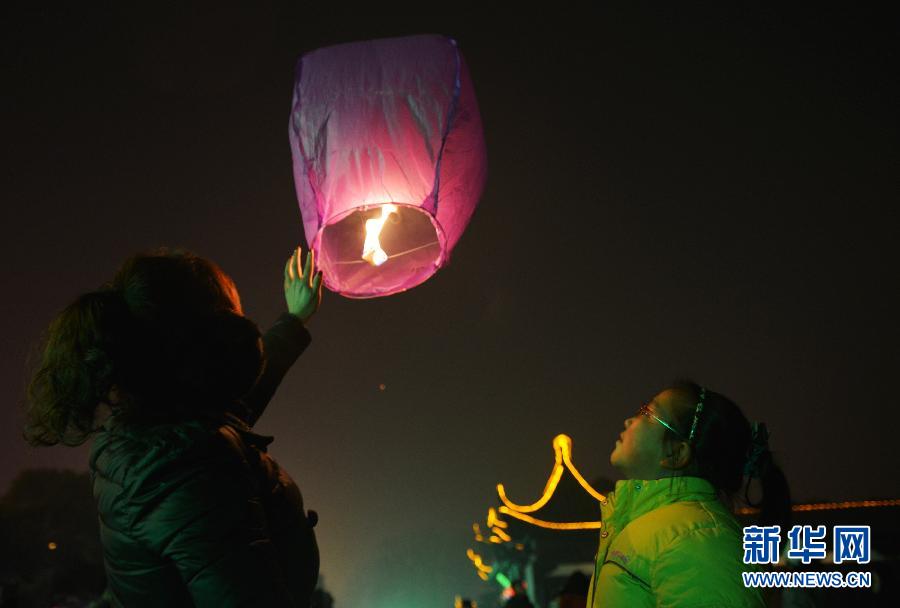 　1月30日，游客在江蘇省鎮(zhèn)江市金山公園門口放飛孔明燈。
