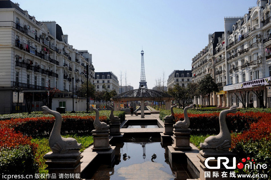 　2014年3月21日，杭州天都城，農(nóng)民在山寨埃菲爾鐵塔下耕作。圖片來源：東方IC