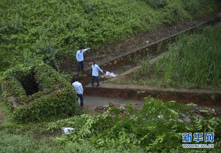 5月18日，工作人員在槽罐車泄漏現(xiàn)場(chǎng)附近的水渠邊查看情況。