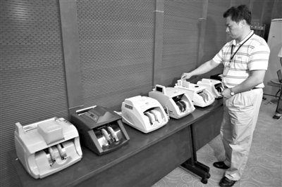 昨日，央行工作人員用各種驗(yàn)鈔機(jī)對(duì)C1F9假幣進(jìn)行測(cè)試，機(jī)器均能及時(shí)作出異常報(bào)警反應(yīng)。新京報(bào)記者 浦