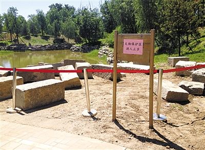 圓明園規(guī)月橋橋體構(gòu)件區(qū)域的警戒線和提示牌。 新京報記者 鄧琦 攝