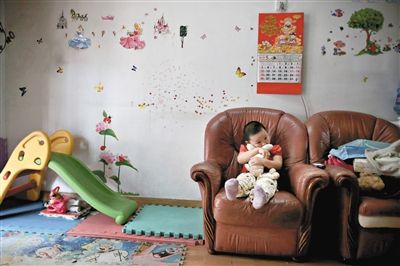 6月14日，未婚媽媽于軍的家里。女兒悅悅抱著兔子玩偶，在聽媽媽手機(jī)上的兒歌，這個(gè)4歲女孩喜歡兔子。