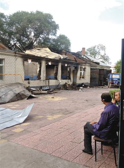 7月27日，海倫聯(lián)合敬老院內(nèi)，幾名老人看著對面被燒毀的特護(hù)病房。新京報(bào)記者 涂重航 攝