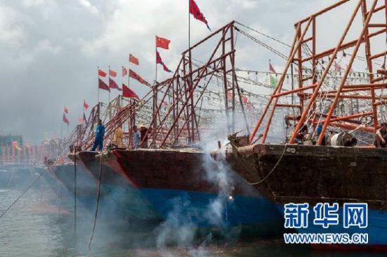 2013年8月1日 南海開漁日 臨高迎新港 8月1日，海南省臨高縣漁民在船上鳴放鞭炮慶祝武蓮港開港。