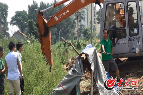 陳寶成手持自制刀斧守在挖掘機(jī)旁阻止便衣民警靠前。駕駛室內(nèi)，張朋珂正向受害人郭曉剛身上澆汽油。（視頻截圖）