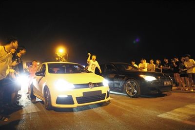 8月24日晚，東壩中街飆車現(xiàn)場，兩輛車并排等待出發(fā)指令，旁邊許多愛好者前來觀看比賽。新京報(bào)記者