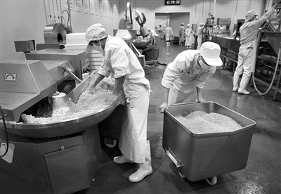 昨日，位于順義李遂開發(fā)區(qū)的慶豐包子鋪配送中心生產(chǎn)車間，工人們正在斬拌胡蘿卜餡料。