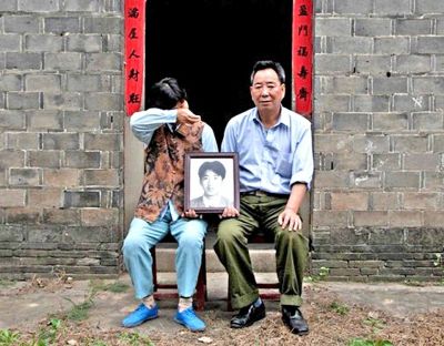 江蘇鎮(zhèn)江，老劉夫婦捧著獨生子的遺像在老家前留影南方都市報供圖L