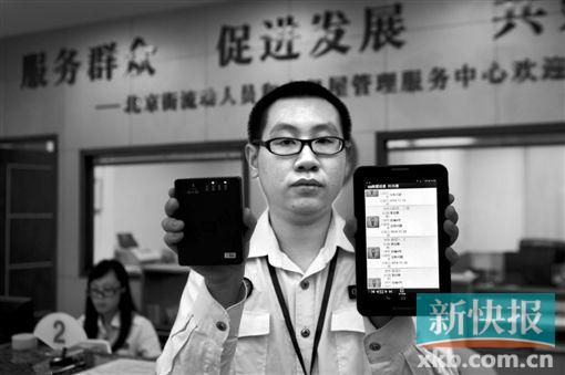 　越秀區(qū)北京街出租屋外來暫住人員管理服務(wù)中心的工作人員展示到出租屋登記來穗人員信息的儀器。