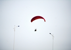 10月25日下午，動力傘從一對路燈上空飛過