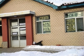 伊春市帶嶺區(qū)一排破舊的平房，房間窗戶上貼滿了“我告饒了”的字樣。
