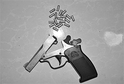 警方從搶劫嫌疑人處起獲的贓款和發(fā)令槍、子彈。警方供圖