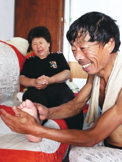 慈成富為老伴按摩。