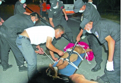 眾人合力將狂犬病發(fā)作的江某控制住。 孫東城 攝