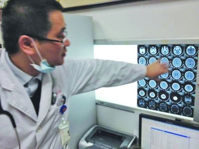醫(yī)生在查看男孩的腦部CT片。薛馬義 攝