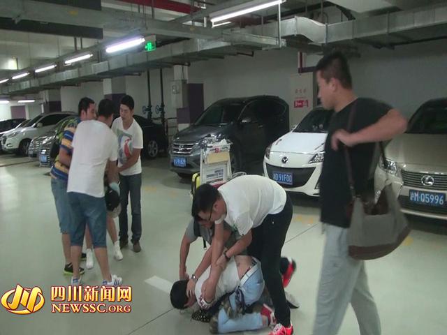 辦案人員在機(jī)場(chǎng)停車(chē)場(chǎng)抓獲胡某及其女友（警方視頻截圖）。