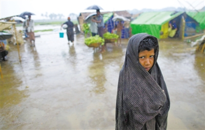 5月14日，緬甸若開邦實兌難民營，羅興亞族難民在雨中行走。熱帶風暴“馬哈森”即將登陸緬甸，這里的難民開始乘船撤離。