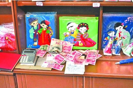 　　2012年6月21日，在朝鮮羅先特別市的一家商店里，柜臺(tái)上散落著一些人民幣。在朝鮮，人民幣比本國(guó)