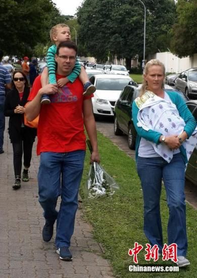 圖為一個(gè)白人家庭，由父母帶著孩子到曼德拉家門外悼念。中新社發(fā) 宋方燦 攝