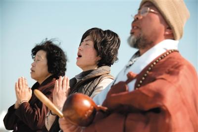 23日，一名僧侶引領(lǐng)人們?yōu)樗勒咂矶\。