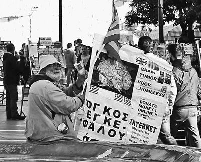 自債務(wù)危機(jī)爆發(fā)以來，希臘承諾實施以減薪、增稅、裁員和私有化為主要內(nèi)容的緊縮和改革政策。一系列的緊縮措施使民眾生活受到嚴(yán)重影響，約1/4的家庭陷入貧困。圖為今年1月希臘大選期間，在雅典市中心國會大廈前廣場乞討的老人。