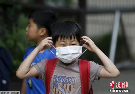 圖為當(dāng)?shù)貢r(shí)間2015年6月8日，韓國(guó)未停課的學(xué)校，學(xué)生課前戴口罩測(cè)體溫。