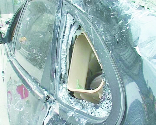 爆炸導(dǎo)致部分窗玻璃碎裂掉落,殃及樓下停放的轎車。