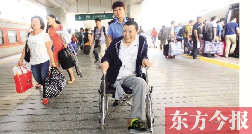 李剛手術(shù)后歸來，在車站工作人員幫助下走出鄭州火車站站臺  東方今報首席記者 張曉冬 攝