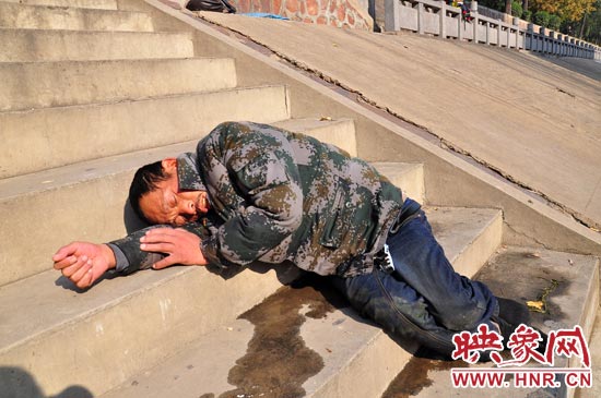 這名男子的衣服以及褲子全濕透了，水從衣褲里流出來，嘴里散發(fā)著濃烈的酒氣。