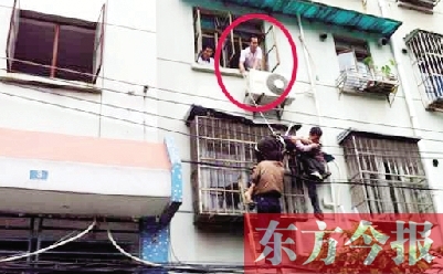 施救現(xiàn)場，劉鵬（圈內(nèi)）先用繩子捆住老太確保安全 勞動報記者 郭娜 供圖